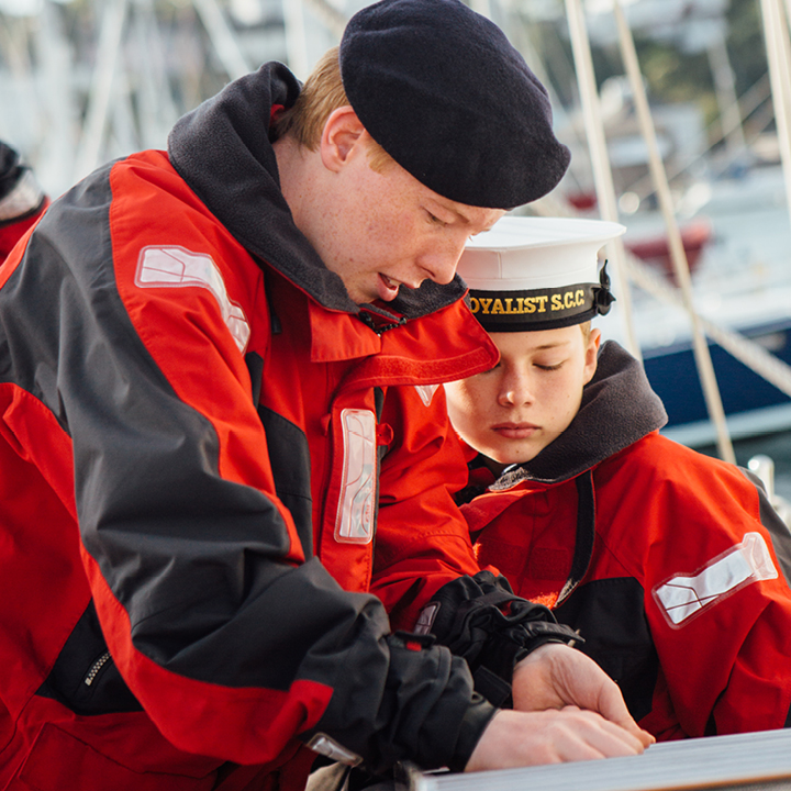 Adult volunteer showing a Sea Cadet a new skill